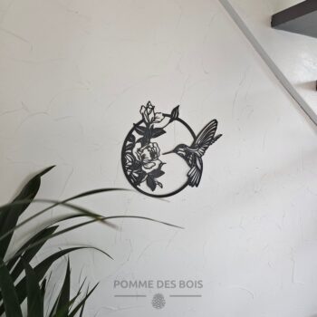 Un colibri dans un cadre avec des fleurs.