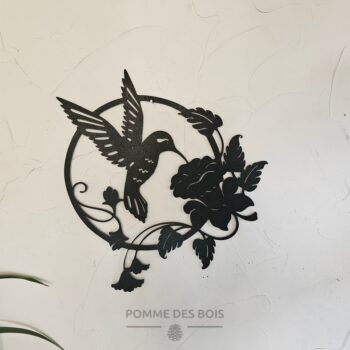 Un colibri dans un cadre rond avec des fleurs.