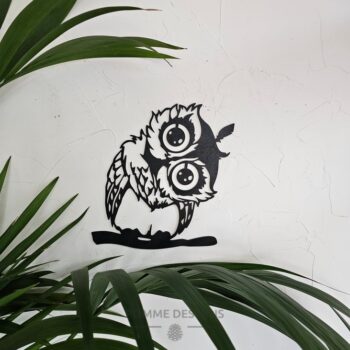 Un hibou sur une branche avec la tête sur le côté.