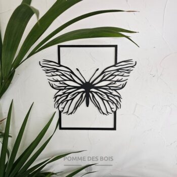 Un papillon avec des arbre dans un cadre.